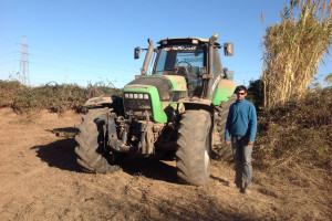 Arnau Vidal, al costat d'un dels tractors de gran potència que fa servir per netejar i preparar els camps pel conreu.